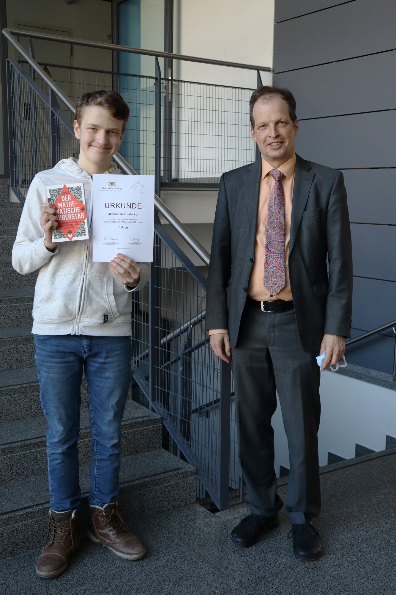 Michael Schmalacker und Schulleiter Dr. Markus Köcher präsentieren die Urkunde zum Landeswettbewerb